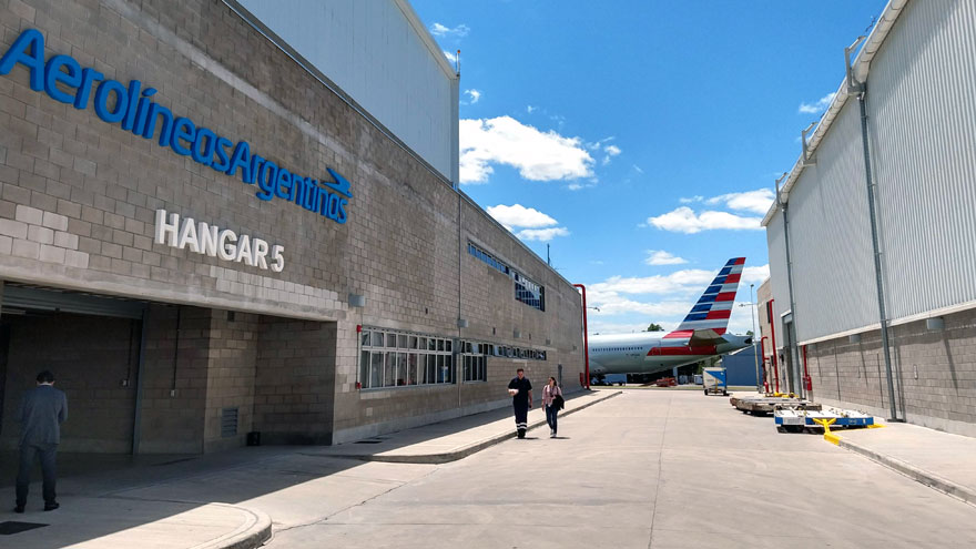 Puerta de entrada al hangar 5 de Ezeiza. Al fondo, estacionado, un Boeing 777 de American Airlines.