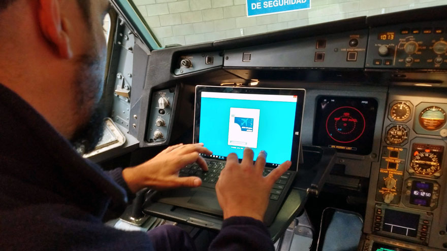 Un técnico ingresa al software AMOS en una tableta Surface en la cabina de vuelo del Airbus A340-300B LV-FPU.